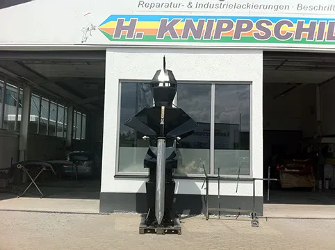 Schwarz lackierte Ritter-Skulptur mit Schwert vor der Werkstatt